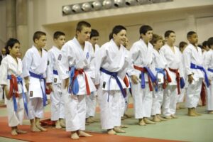 photo compétiteurs enfants av ceintures rouge et bleu au salut